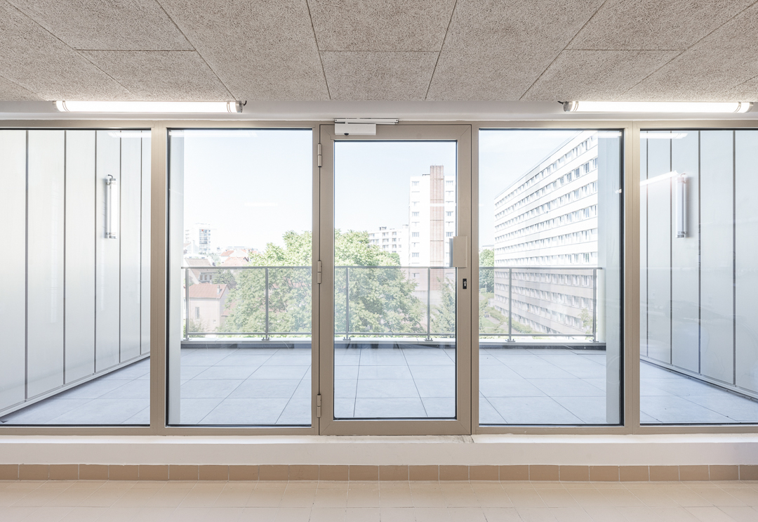 Large terrasse en hauteur depuis la laverie d'une résidence étudiante au plafond en fibre de bois